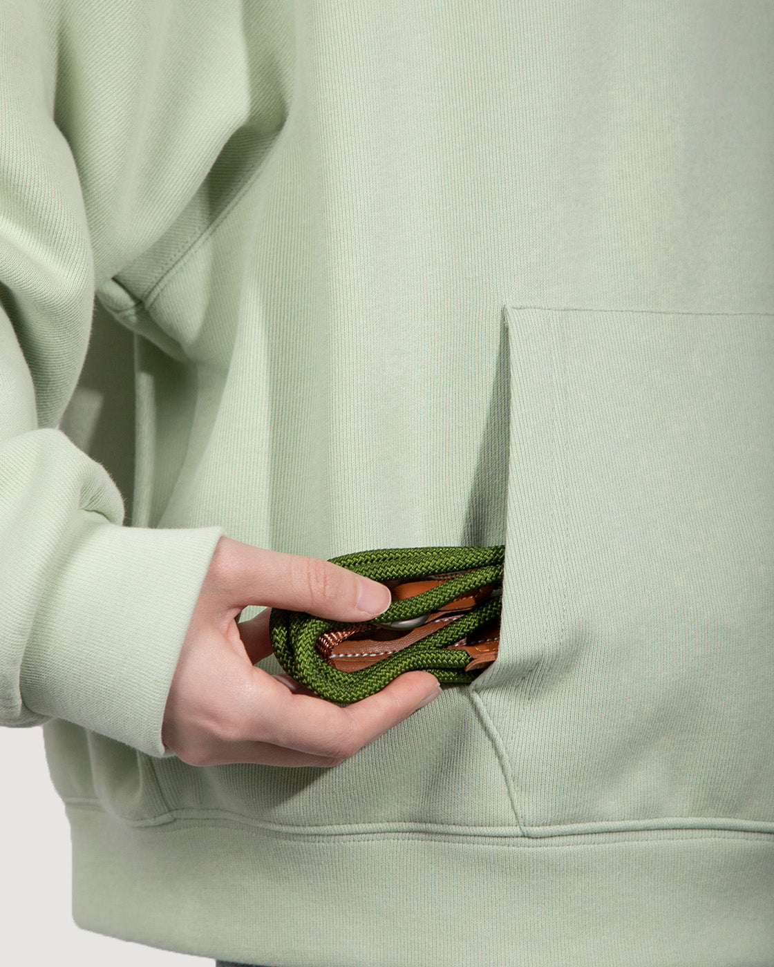 Close-up of the moss green dog slip lead, highlighting its retractable design that can be conveniently stored in a pocket for easy carrying.
