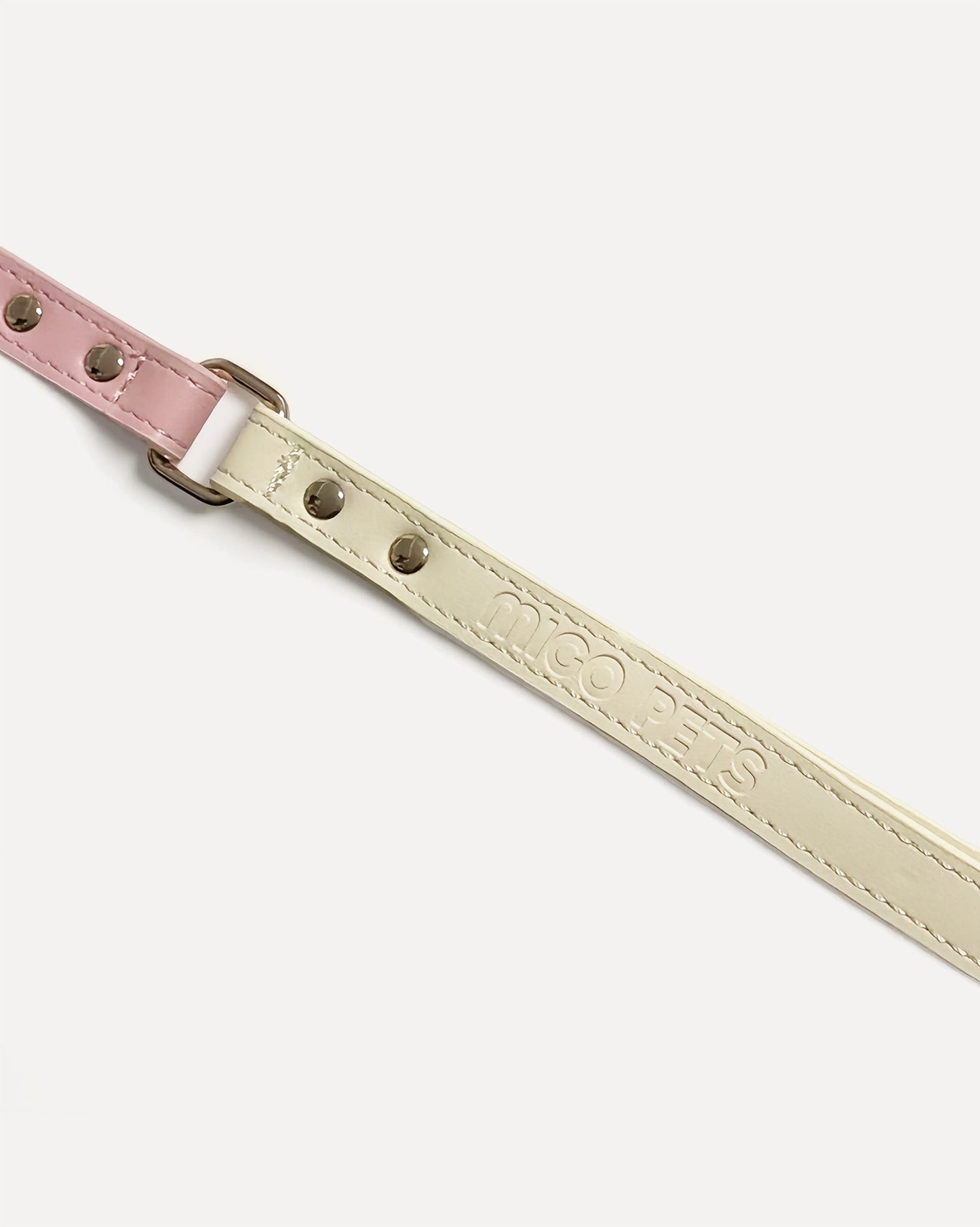 Close-up of a two-tone leather dog leash in pink with gold hardware and 'MIGO PETS' embossed on the strap.