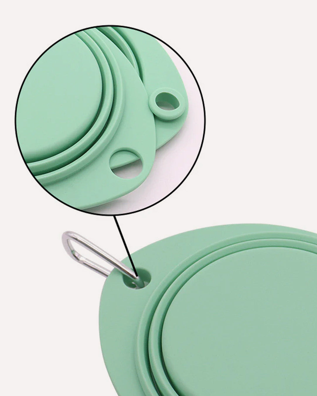 Close-up of the cyan collapsible travel double dog bowl, emphasizing the convenient carabiner attachment and the dual hole design for easy portability and secure hanging.
