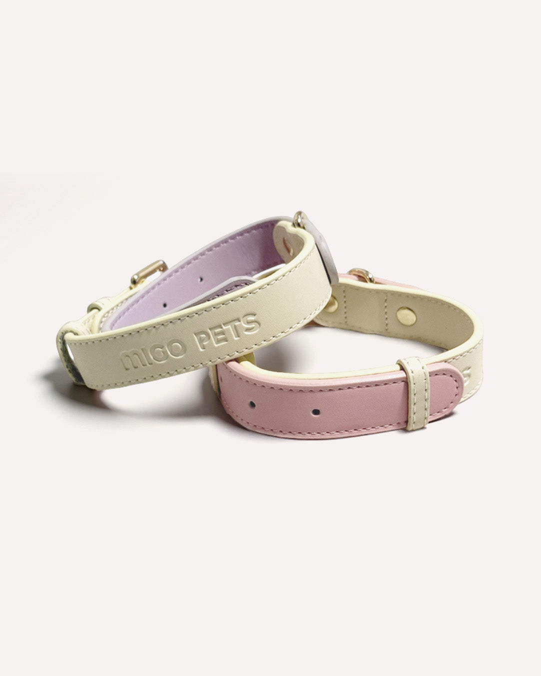 Close-up of two-tone genuine leather dog collars in pink and violet purple.
